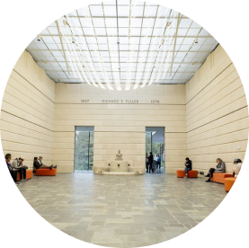 Visitors sitting in Fuller Garden Court with a figurative scultpure over a fountain in the background.